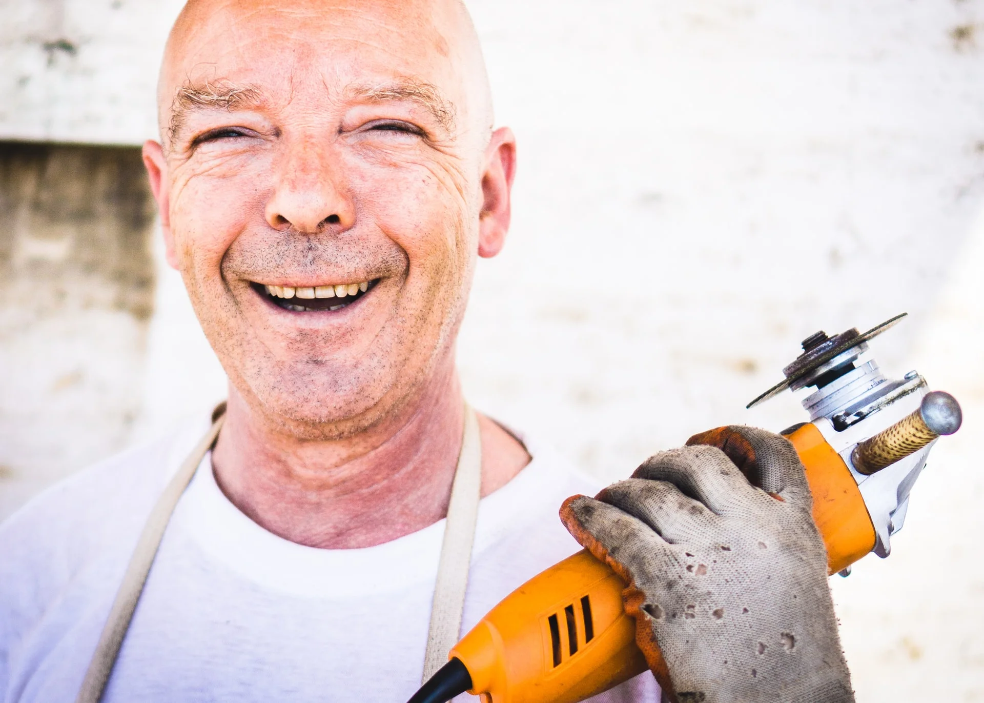 a man smiling with a drill