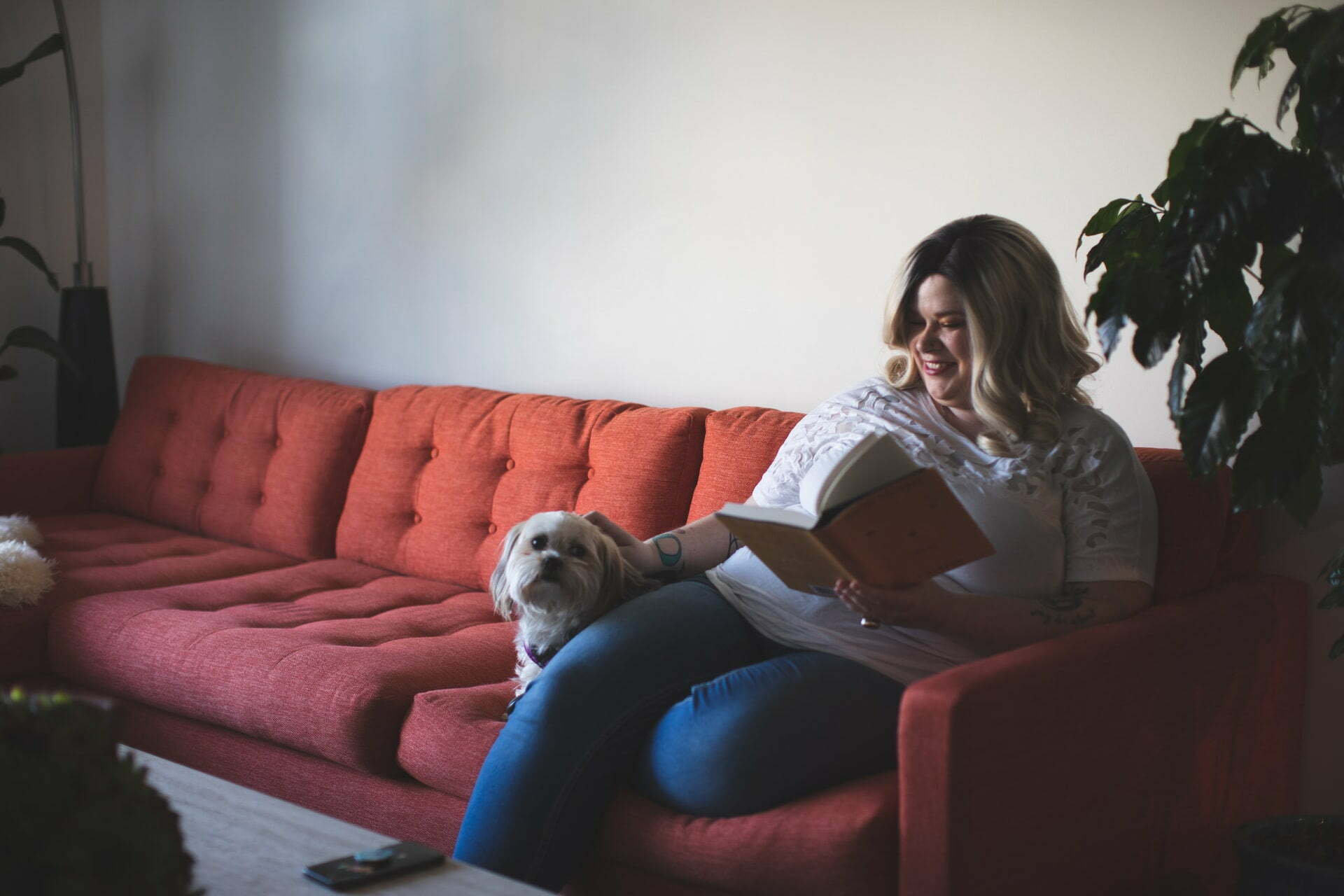 a woman sitting on a couch with a dog