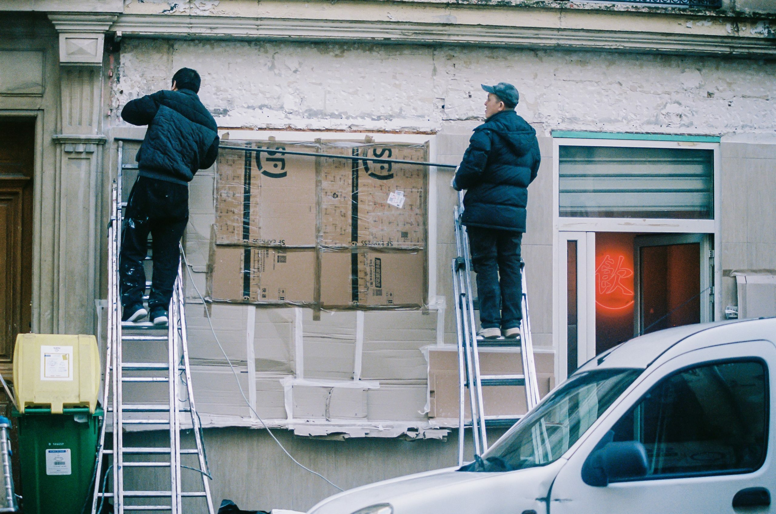 men standing on ladders outside a building