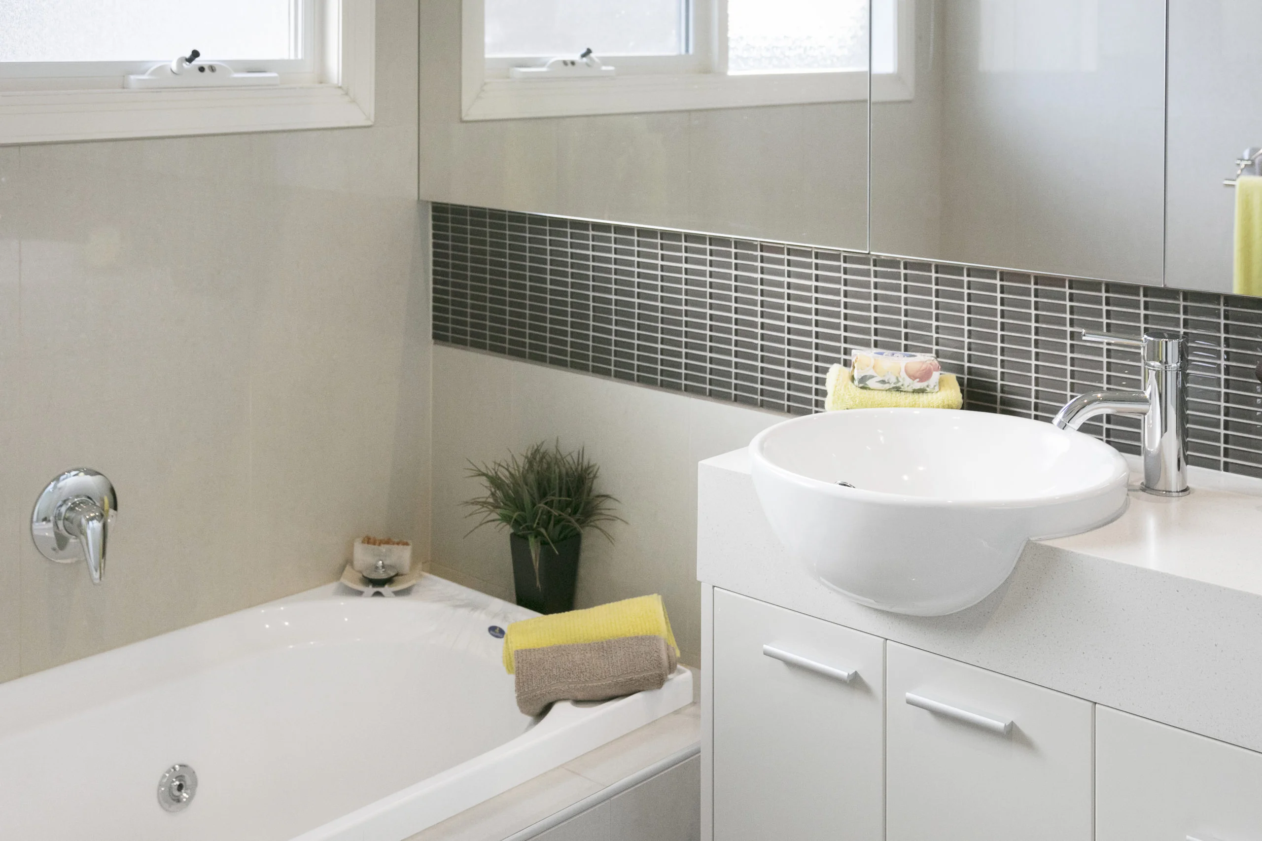 a bathroom with a sink and a plant in the corner