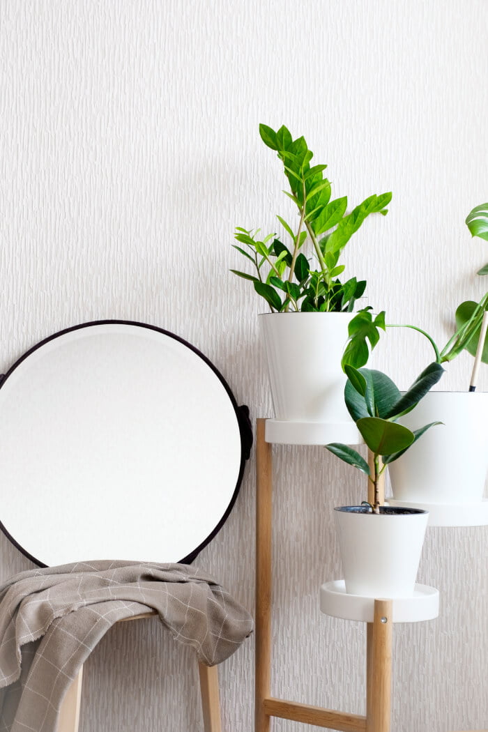 a chair next to a table with potted plants