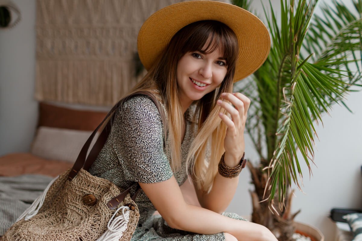 a woman sitting on a couch with a cowboy hat on her head