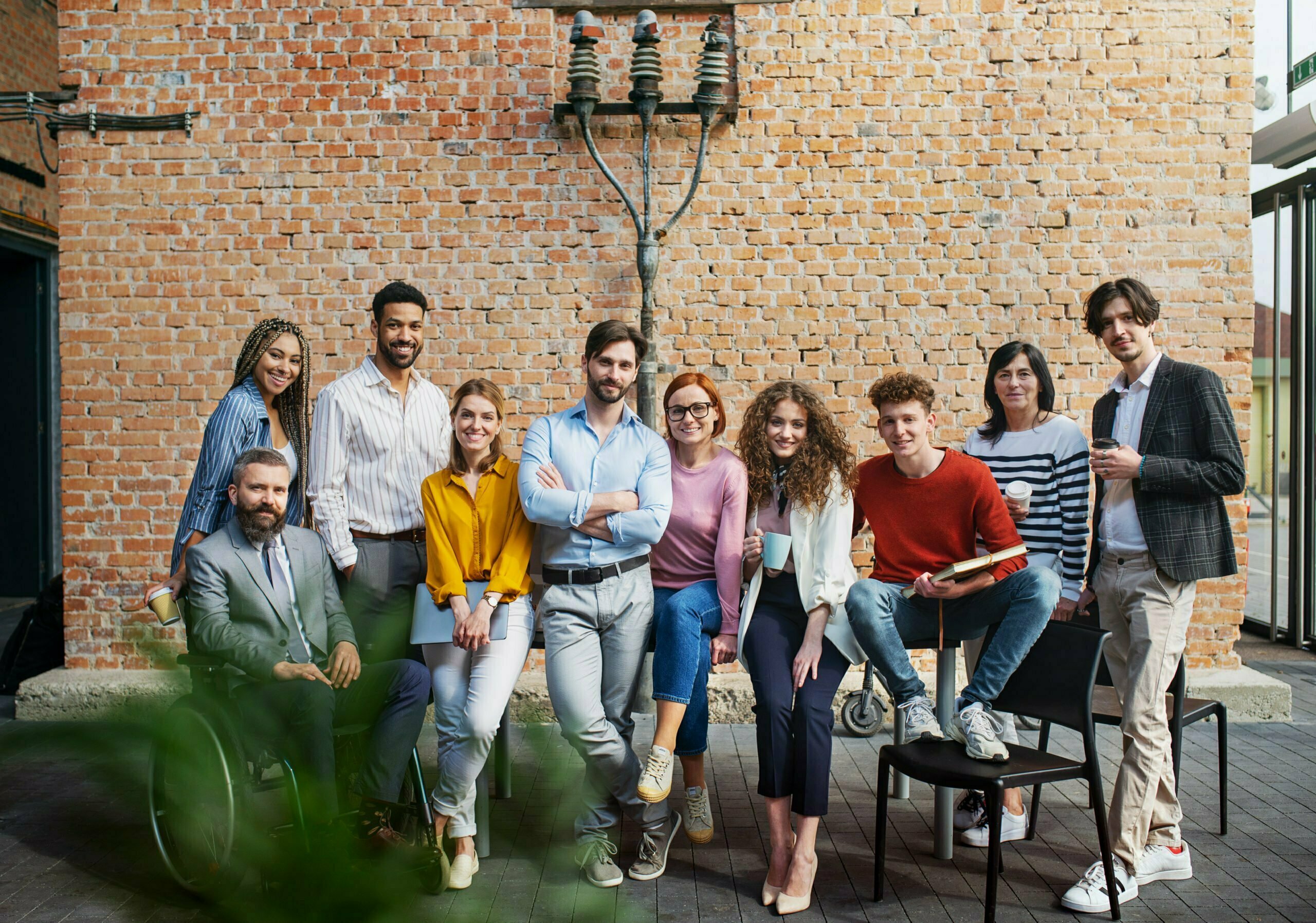 Group of entrepreneurs looking at camera indoors in office, inclusion of disabled ceoncept