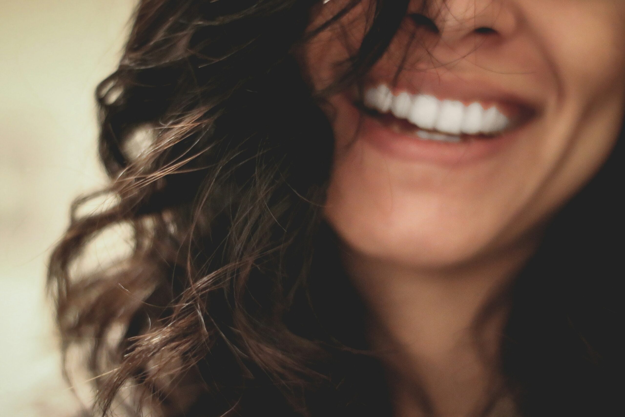 a woman smiling with her hair pulled back